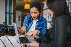 a woman and a man looking at a laptop