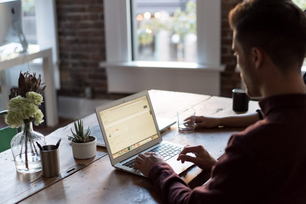 a person sitting at a table looking at a tablet