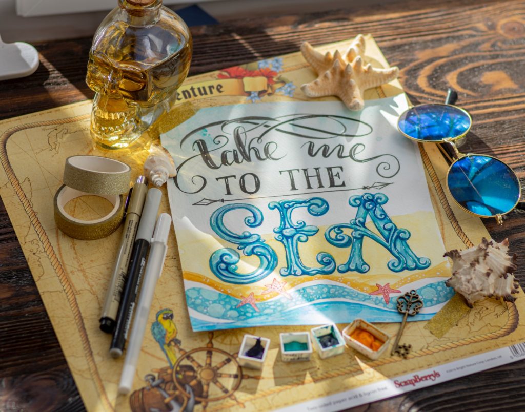 a table with a blue and white sign and a pen and a glass of beer