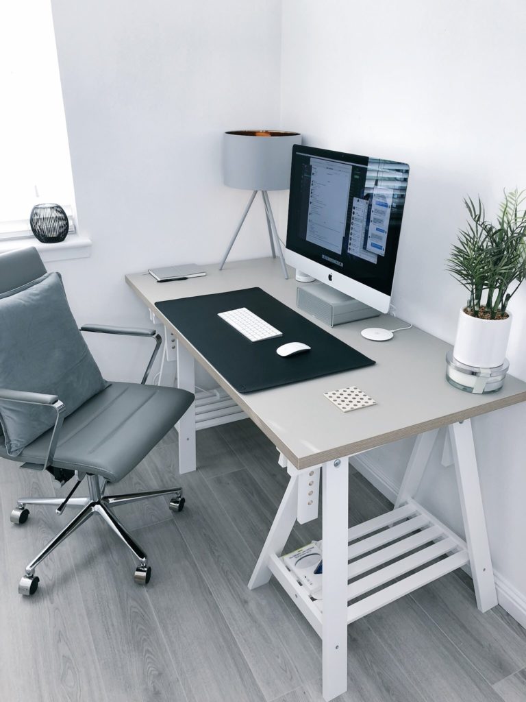 a desk with a computer and a chair