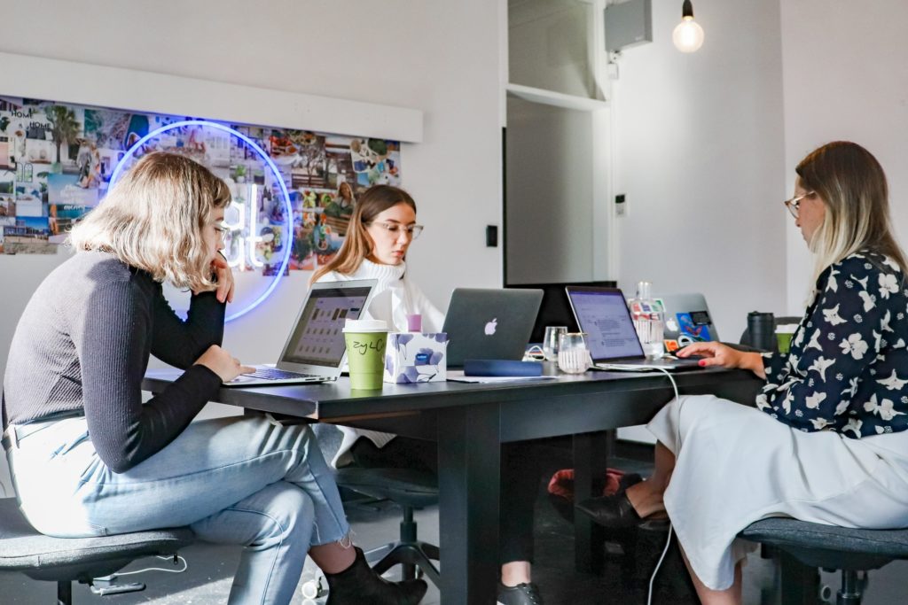 a group of women working on laptops