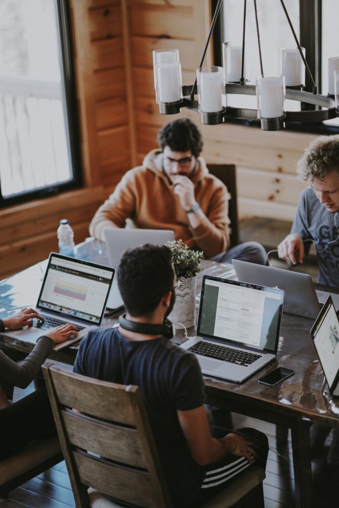 a group of people working on laptops